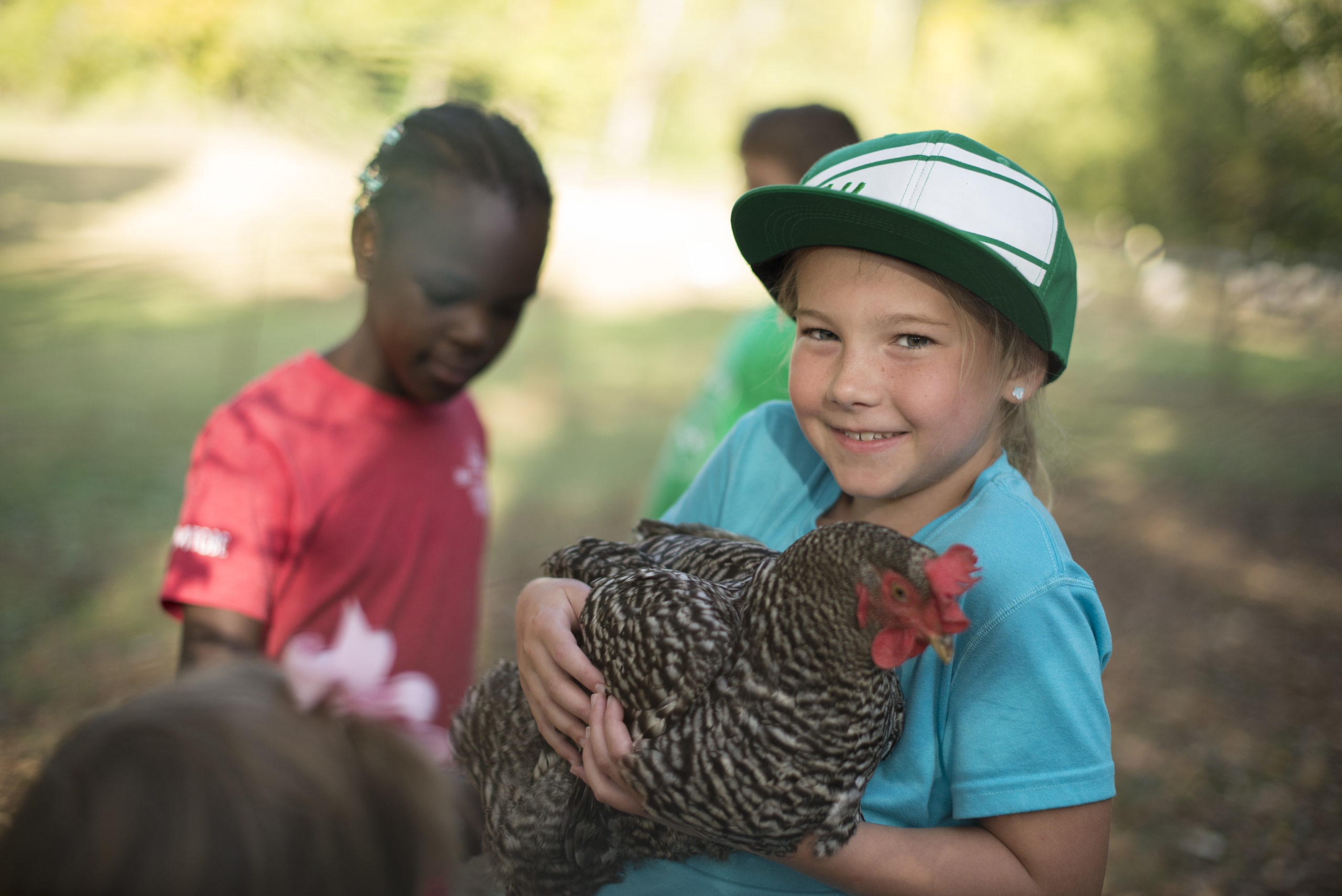 A child participating in TN 4-H holding a chicken and smiling at the camera.
