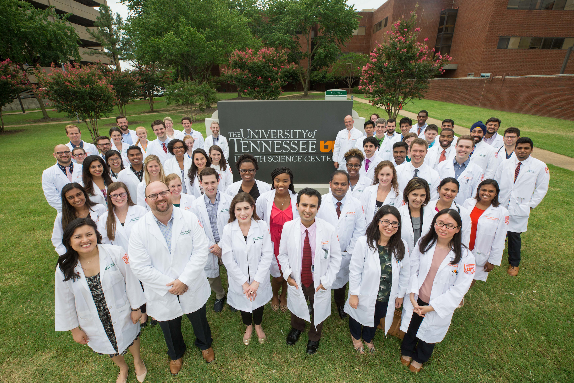 A group of UT Health Science residents standing outside in lab coats.